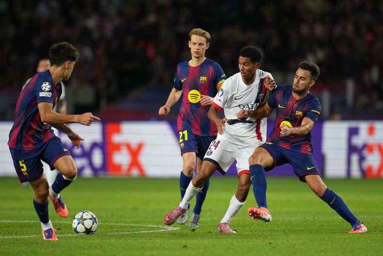 Senny Mayulu empujado por jugadores del Barcelona en el encuentro de la Liga de Campeones el miércoles primero de octubre del 2025. (AP Foto/Emilio Morenatti)