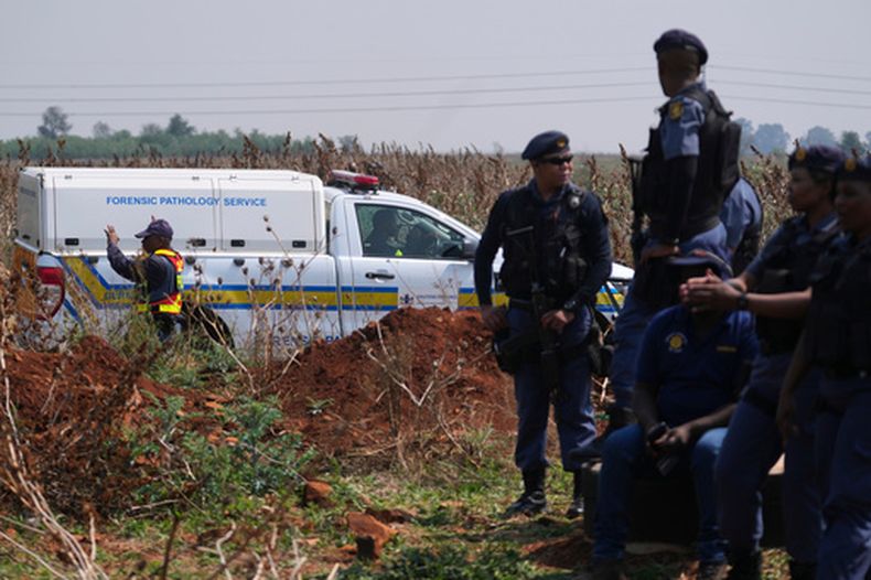 Investigadores forenses trabajan en el lugar donde se encontró el cuerpo de una mujer a las afueras de Johannesburgo, Sudáfrica, el jueves 17 de septiembre de 2026. (AP Foto/Themba Hadebe)