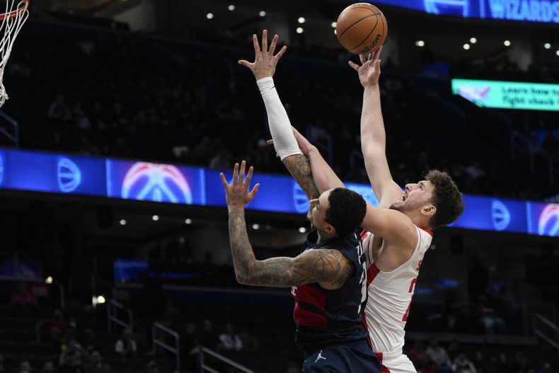 El pívot de los Rockets de Houston, Alperen Sengun (28), se enfrenta al alero de los Wizards de Washington, Kyle Kuzma (33), durante la primera mitad de un partido de baloncesto de la NBA, el martes 7 de enero de 2025, en Washington. (AP Foto/Jess Rapfogel)