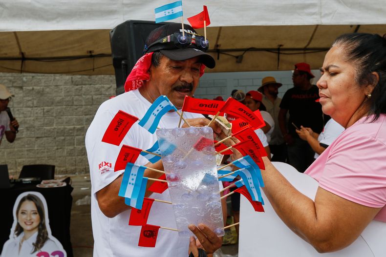Un hombre vende banderas de Honduras y del partido gobernante LIBRE durante cierre de campaña de la candidata presidencial Rixi Moncada en San Pedro Sula, Honduras, el sábado 22 de noviembre de 2025. Las elecciones generales son el 30 de noviembre. (Foto AP/Delmer Martinez)