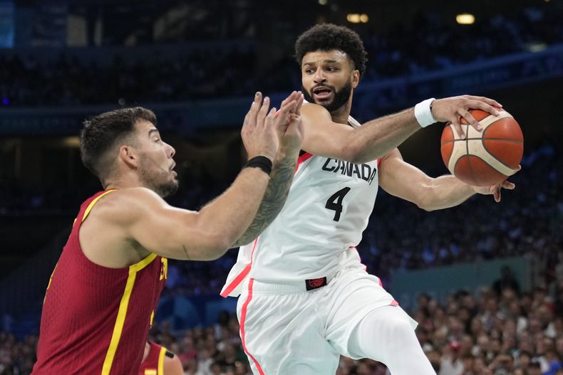 ARCHIVO - Jamal Murray, a la derecha, de Canadá, busca pasar el balón alrededor de Willy Hernangómez, de España, a la izquierda, en un partido de baloncesto masculino en los Juegos Olímpicos de Verano de 2024, el 2 de agosto de 2024, en Villeneuve-dAscq, Francia. (AP Foto/Mark J. Terrill, Archivo)