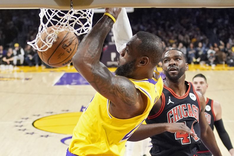 LeBron James, de los Lakers de Los Ángeles, realiza una clavada frente a Patrick Williams, de los Bulls de Chicago, en el duelo del jueves 25 de enero de 2024 (AP Foto/Mark J. Terrill)