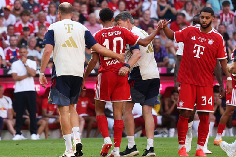 Jamal Musiala (al centro), del Munich, abandona el campo debido a una lesión durante un partido de fútbol de pretemporada entre el FC Bayern Munich y el RB Leipzig en Múnich, Alemania, el sábado 15 de agosto de 2026. (Karl-Josef Hildenbrand/dpa vía AP)