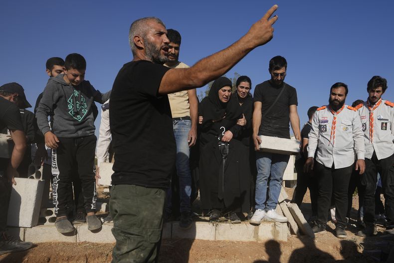 Dolientes sepultan los cuerpos de sus familiares muertos en ataques aéreos israelíes, el viernes 27 de septiembre de 2024, en el poblado de Karak, valle de Bekaa, en el este de Líbano. (AP Foto/Hassan Ammar)