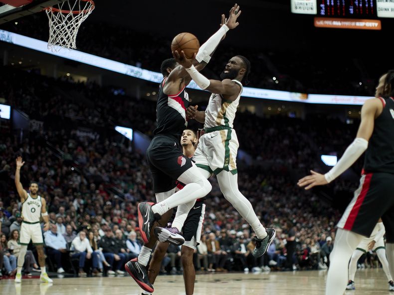Jaylen Brown, de los Celtics de Boston, intenta una canasta sobre Deandre Ayton, de los Trail Blazers de Portland, durante la primera mitad del juego de baloncesto de la NBA, en Portland, el lunes 11 de marzo de 2024. (AP Foto/Craig Mitchelldyer)