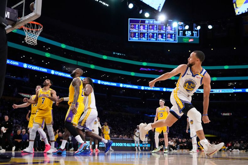El guardia de los Warriors de Golden State, Stephen Curry (derecha), observa cómo entra su disparo durante la primera mitad de un partido de básquetbol de la NBA contra los Lakers de Los Ángeles, el jueves 3 de abril de 2025, en Los Ángeles. (Foto AP/Mark J. Terrill)