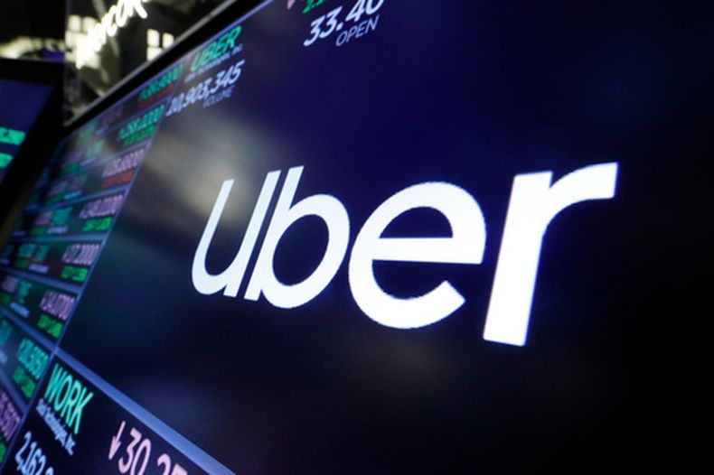 ARCHIVO – El logotipo de Uber arriba de un puesto de intercambio comercial en el piso de la Bolsa de Valores de Nueva York, el 16 de agosto de 2019. (AP Foto/Richard Drew, Archivo)