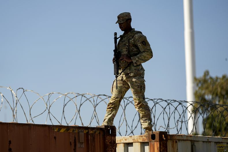 Un elemento de la Guardia Nacional camina sobre vagones de tren cubiertos con alambre de púas a lo largo de la frontera entre México y Texas, el 3 de enero de 2024, en Eagle Pass, Texas. (AP Foto/Eric Gay, Archivo)