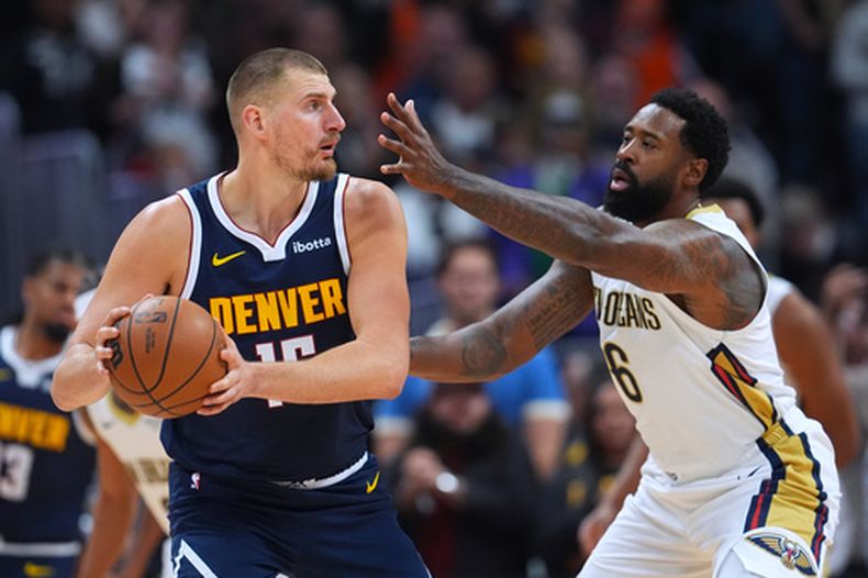 El serbio Nikola Jokić, de los Nuggets de Denver, trata de avanzar frente a DeAndre Jordan, de los Pelicans de Nueva Orleáns, el sábado 24 de octubre de 2026 (AP Foto/David Zalubowski)
