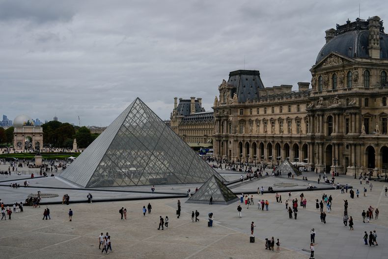 ARCHIVO - Gente camina ante el museo del Louvre, el domingo 31 de agosto de 2025, en París. (AP Foto/Julia Demaree Nikhinson, Archivo)