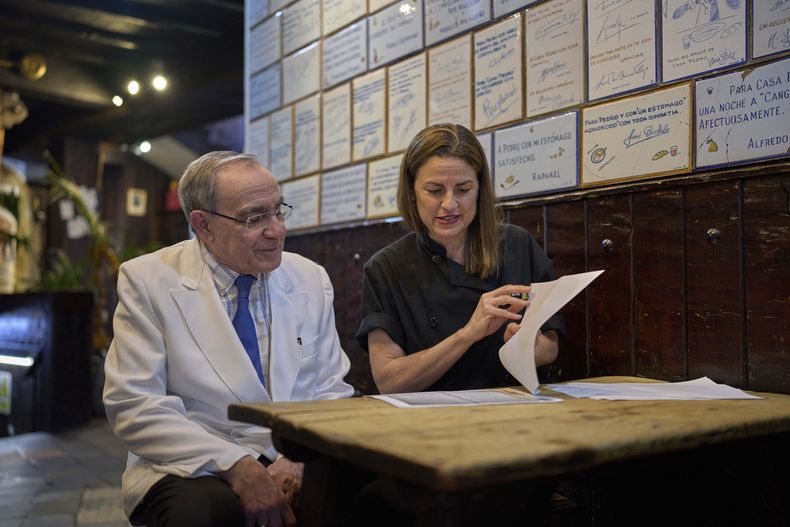 Irene Guiñales y Pedro Guiñales del Valle, propietarios y gerentes del restaurante Casa Pedro, revisan documentos sobre la apertura del establecimiento en Madrid, España, el 16 de mayo de 2025. (AP Foto/Manu Fernandez)