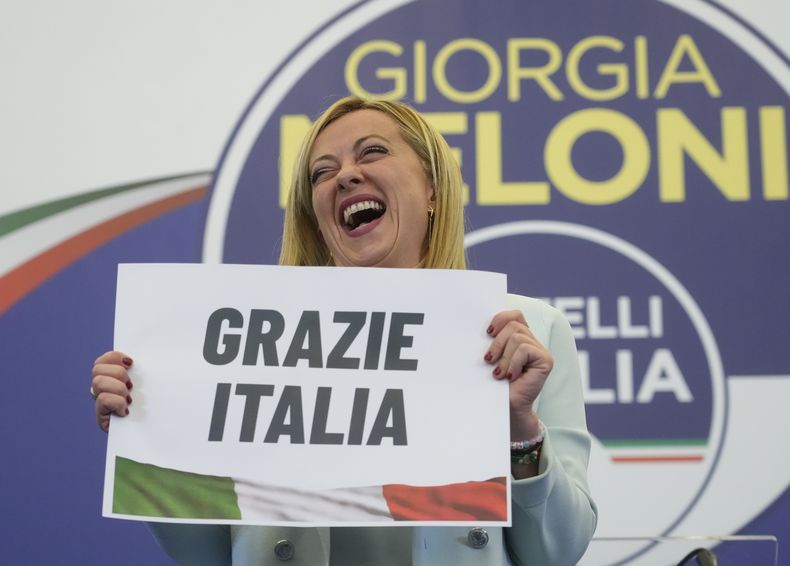 ARCHIVO - Giorgia Meloni, líder del partido Hermanos de Italia, de extrema derecha, sostiene un letrero que reza Gracias Italia en la madrugada del lunes 26 de septiembre de 2022, en la sede electoral de su partido, en Roma. (AP Foto/Gregorio Borgia, archivo)