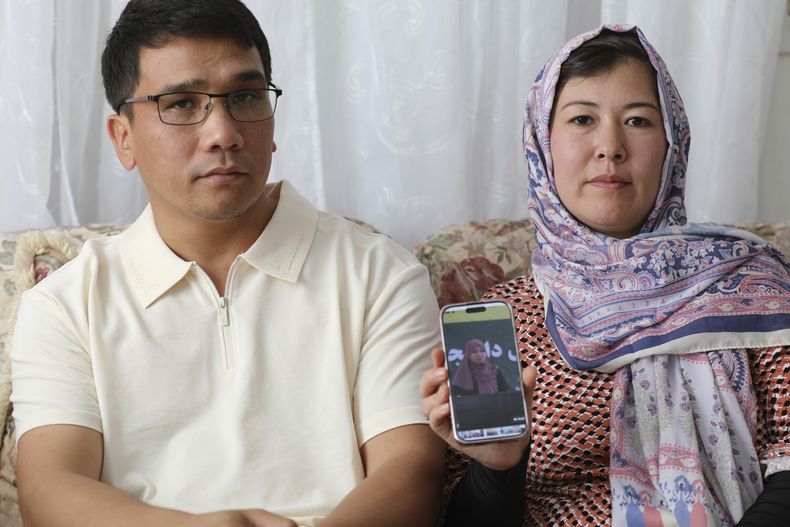 Mohammad Sharafoddin, a la izquierda, y su esposa, Nuriya, a la derecha, muestran una foto de su sobrina en Afganistán que no podrá viajar a Estados Unidos en virtud a una nueva restricción de viajes, durante una entrevista en su residencia, el sábado 7 de junio de 2025, en Irmo, Carolina del Sur. (AP Foto/Jeffrey Collins)