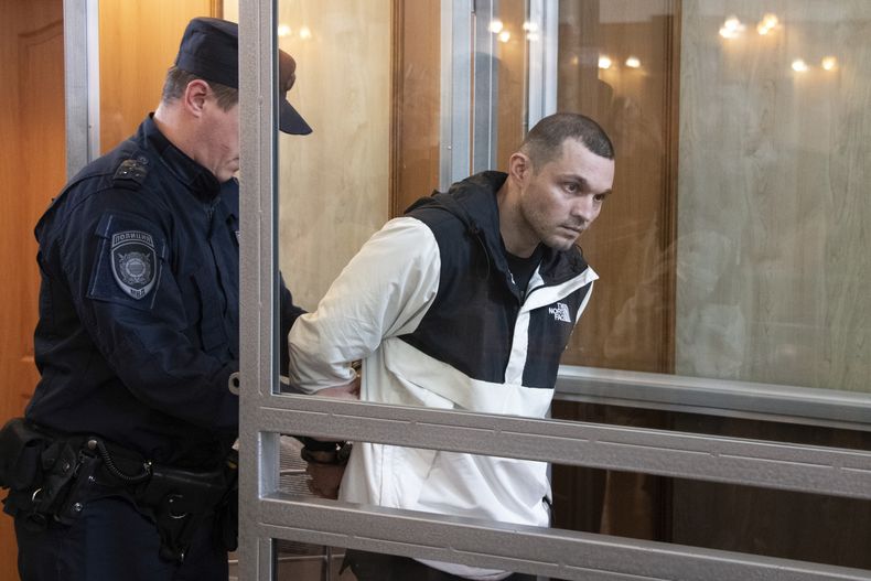 El sargento estadounidense Gordon Black es escoltado a una celda transparente en una sala judicial en Vladivostok, Rusia, el jueves 6 de junio de 2024. Una corte en la remota localidad oriental rusa de Vladivostok comenzó el jueves el juicio a un soldado estadounidense detenido en la ciudad este año y acusado de robo. (AP Foto/)