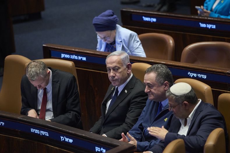 El primer ministro de Israel, Benjamin Netanyahu, rodeado por ministros del gobierno, asiste a una sesión del Knéset, el parlamento israelí, en Jerusalén, el lunes 14 de julio de 2025. (AP Foto/Ohad Zwigenberg)