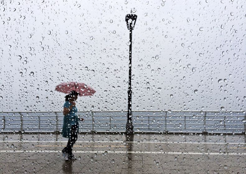 Una libanesa camina por el malec&oacute;n en Beirut, L&iacute;bano, el 8 de mayo del 2014. Intensas lluvias afectaron parte del Oriente Medio el jueves incluso Israel y Jordania. (AP Foto/Hussein Malla)