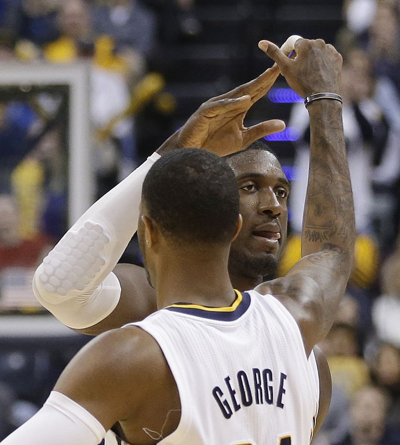 Paul George recibe la felicitaci&oacute;n de Roy Hibbert, su compa&ntilde;ero en los Pacers de Indiana, durante el partido del martes 31 de diciembre de 2013, frente a los Cavaliers de Cleveland (AP Foto/Darron Cummings)