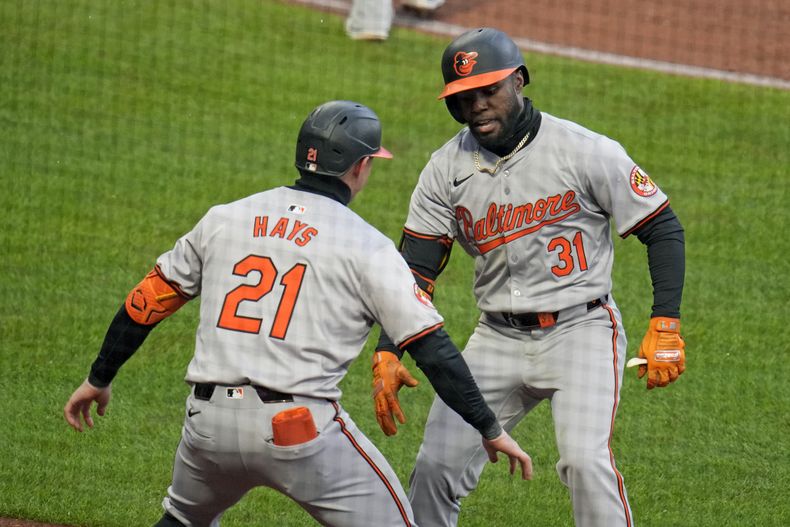 Cedric Mullins (31), de los Orioles de Baltimore, celebra con su compañero Austin Hays mientras regresa a la caseta luego de batear un jonrón solitario frente al relevista de los Piratas de Pittsburgh, Hunter Stratton, durante la octava entrada del juego de béisbol en Pittsburgh, el viernes 5 de abril de 2024. (AP Foto/Gene J. Puskar)