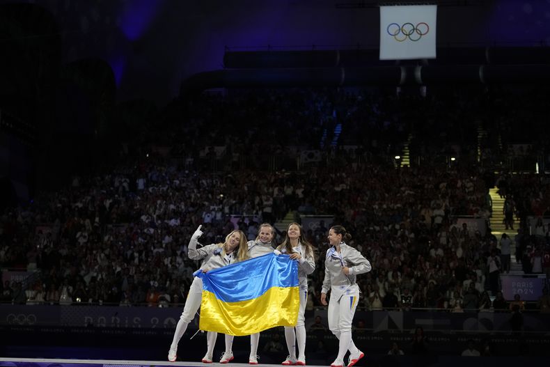 Las ucranianas, Olga Kharlan, Alina Komaschchuk, Olena Kravatska y Yuliia Bakastova festejan su oro en esgrima, en la prueba de sable por equipos, el sábado 3 de agosto de 2024 (AP Photo/Andrew Medichini)