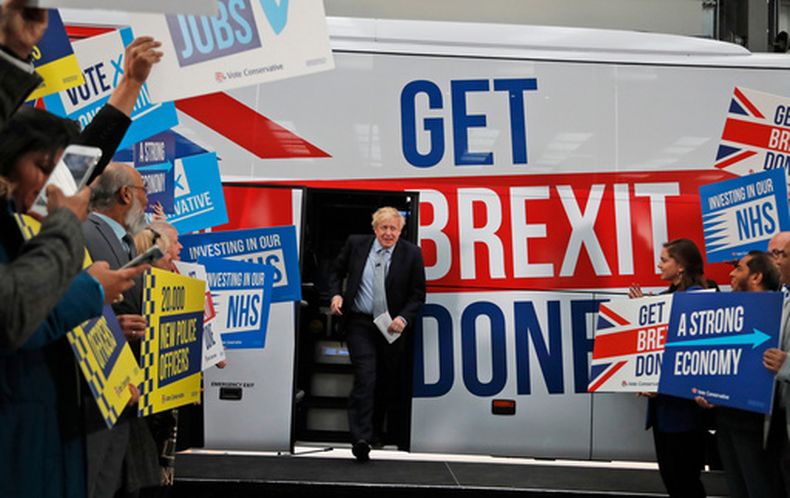 ARCHIVO - El entonces primer ministro británico, Boris Johnson, se dirige a sus seguidores antes de subir a un autobús de campaña electoral en Manchester, Inglaterra, el viernes 15 de noviembre de 2019. (AP Foto/Frank Augstein, Pool, Archivo)