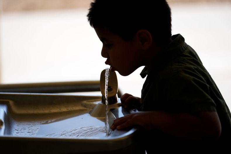 Un niño bebe agua de una fuente en la escuela Cuyama Elementary School, en New Cuyama, California, el 20 de septiembre del 2023. (AP foto/Marcio Jose Sanchez)