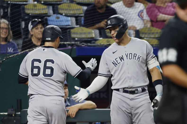 Kyle Higashioka (66), de los Yanquis de Nueva York, es felicitado por Aaron Judge, derecha, después de anotar la carrera de la ventaja con un sencillo de Estevan Florial durante la sexta entrada del juego de béisbol en contra de los Reales de Kansas City, el sábado 30 de septiembre de 2023, en Kansas City, Missouri. (AP Foto/Colin E. Braley)