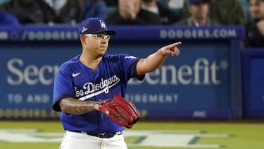 El mexicano Julio Urías, abridor de los Dodgers de Los Ángeles, hace un gesto al campocorto venezolano Miguel Rojas, durante el juego del martes 2 de mayo de 2023, ante los Filis de Filadelfia (AP Foto/Mark J. Terrill)