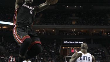 americateve | LeBron James (6), del Heat de Miami, cuelga del aro despu&eacute;s de clavar el bal&oacute;n frente a Bismack Biyombo (0), de los Bobcats de Charlotte, en la primera mitad del juego del s&aacute;bado 16 de noviembre de 2013, en Charlotte, Carolina del Nor