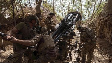 Soldados de la 148va brigada de artillería del ejército de Ucrania cargan munición en un M777 antes de disparar contra posiciones rusas en el frente, en la región ucraniana de Zaporiyia, el 7 de agosto de 2025. (AP Foto/Evgeniy Maloletka)