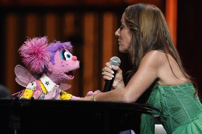 Abby Cadabby, de Sesame Street, a la izquierda, se presenta con Tayla Lynn en el Grand Ole Opry, el jueves 14 de agosto de 2025, en Nashville, Tennessee. (Foto AP/George Walker IV)