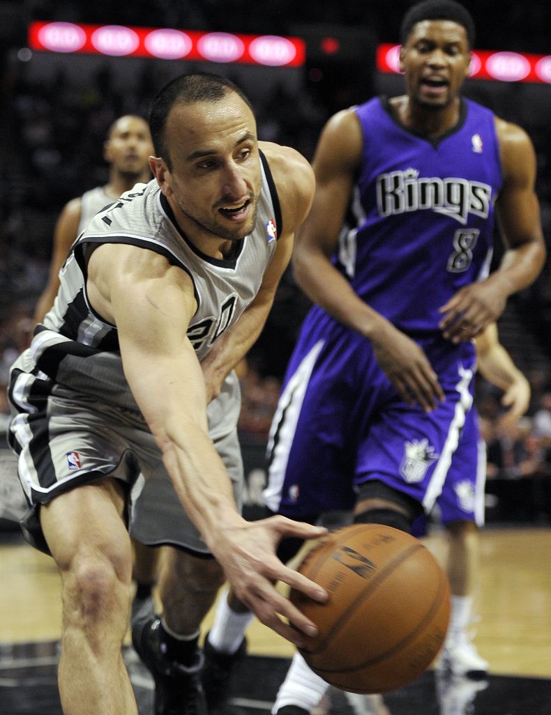 El jugador argentino Emanuel Gin&oacute;bili, de los Spurs de San Antonio, persigue un bal&oacute;n suelto ante la mirada de Rudy Gay, de los Kings de Sacramento, en la primera mitad del juego del domingo 29 de diciembre de 2013, en San Antonio. (Foto AP/