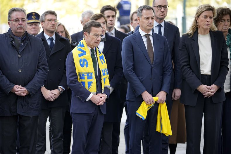 El Primer Ministro de Suecia Ulf Kristersson, al centro e izquierda, y el Primer Ministro de Bélgica Alexander De Croo, dentro derecha, participan en una conmemoración a las víctimas de un tiroteo en el centro de Bruselas, el miércoles 18 de octubre de 2023. La policía de Bélgica abatió a tiros el martes a un tunecino extremista acusado de matar a dos aficionados suecos en las calles de Bruselas. (AP Foto/Martin Meissner)