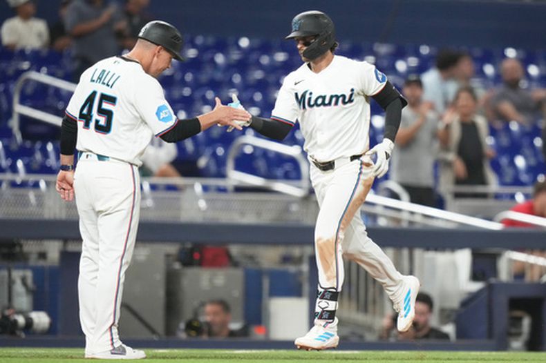 Connor Norby (derecha), de los Marlins de Miami, es recibido por el coach de tercera base Blake Lalli (45) tras conectar un jonrón solitario durante la séptima entrada de un juego de béisbol contra los Rojos de Cincinnati, el miércoles 8 de abril de 2026, en Miami. (Foto AP/Lynne Sladky)