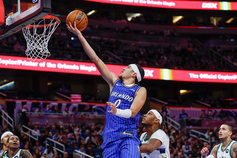 Anthony Black (0), del Magic de Orlando, alista una bandeja sobre Myles Turner, centro derecha, de los Bucks de Milwaukee, durante la segunda mitad del juego de baloncesto de la NBA, el lunes 9 de febrero en Orlando, Florida. (AP Foto/Kevin Kolczynski)