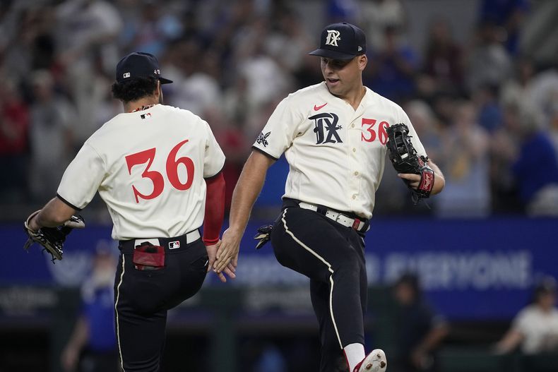 Jonathan Ornelas (36) y Nathaniel Lowe, de los Rangers de Texas, festejan la victoria sobre los Atléticos de Oakland, el sábado 9 de septiembre de 2023 (AP Foto/Tony Gutierrez)