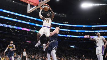 El alero de los Lakers de Los Ángeles LeBron James clava el balón frente al pívot de los Nuggets de Denver Nikola Jokic en el juego 4 de la serie de primera ronda el sábado 27 de abril del 2024. (AP Foto/Mark J. Terrill)