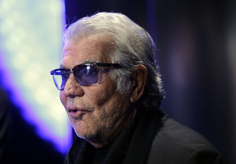ARCHIVO - El diseñador de moda italiano Roberto Cavalli responde a las preguntas de un reportero de televisión antes del inicio del desfile de la colección para damas Primavera-Verano 2014 de Just Cavalli, parte de la Semana de la Moda de Milán, presentado en Milán, Italia, el 19 de septiembre de 2013. Cavalli, conocido por su estilo extravagante y glamoroso, murió el viernes 12 de abril de 2024 a los 83 años, anunció su compañía en una publicación de Instagram. (Foto AP/Luca Bruno, archivo)