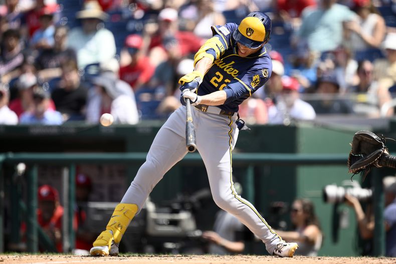 Christian Yelich de los Cerveceros de Milwaukee batea un sencillo ante los Nacionales de Washington, el domingo 3 de agosto de 2025, en Washington. (AP Foto/Nick Wass)