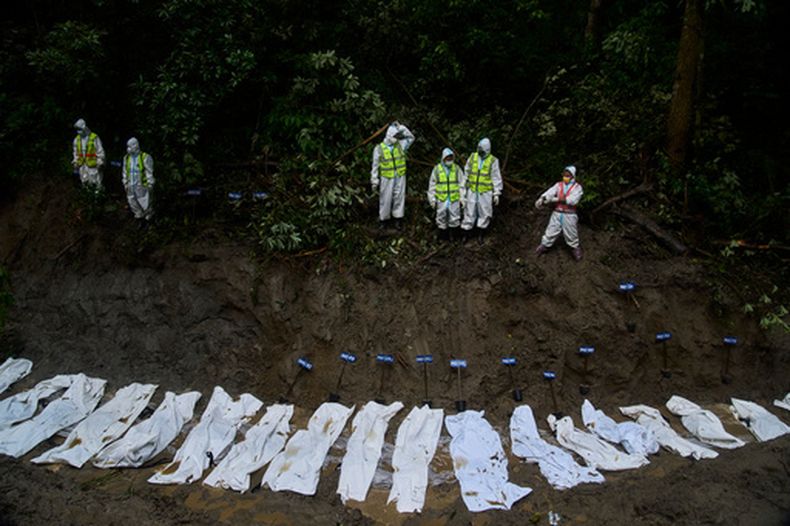 Efectivos de la policía de Nepal preparan los cuerpos de víctimas de las inundaciones repentinas para un entierro masivo en Katmandú, Nepal, el 1 de septiembre de 2026. (AP Foto/Niranjan Shrestha)
