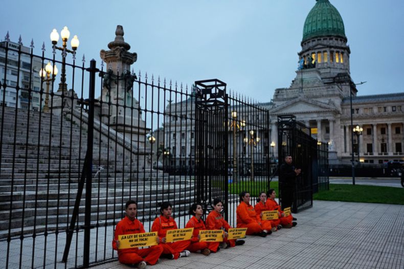 Activistas de Greenpeace permanecen sentados tras ser detenidos a las afueras del Congreso mientras los legisladores debaten la propuesta del gobierno del presidente Javier Milei para reformar la ley de protección de glaciares en Buenos Aires, Argentina, el miércoles 8 de abril de 2026. (AP Foto/Natacha Pisarenko)