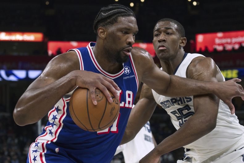Joel Embiid, de los 76ers de Filadelfia, avanza junto a Trey Jemison, de los Grizzlies de Memphis, en el duelo del sábado 6 de abril de 2024 (AP Foto/Nikki Boertman)