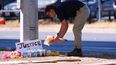 Un hombre coloca flores cerca del lugar donde un venezolano fue baleado por un agente del ICE el día anterior en Austin, Texas, lunes 21 de septiembre de 2026. (Foto AP/Eric Gay)