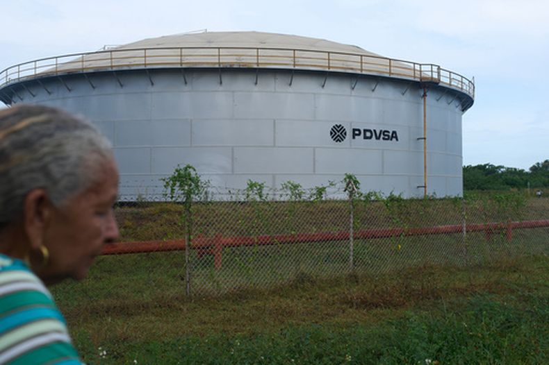 Una mujer pasa junto a un tanque de almacenaje de la petrolera estatal venezolana, PDVSA, en Cabimas, Venezuela, el 1 de septiembre de 2026. (AP Foto/Ariana Cubillos)