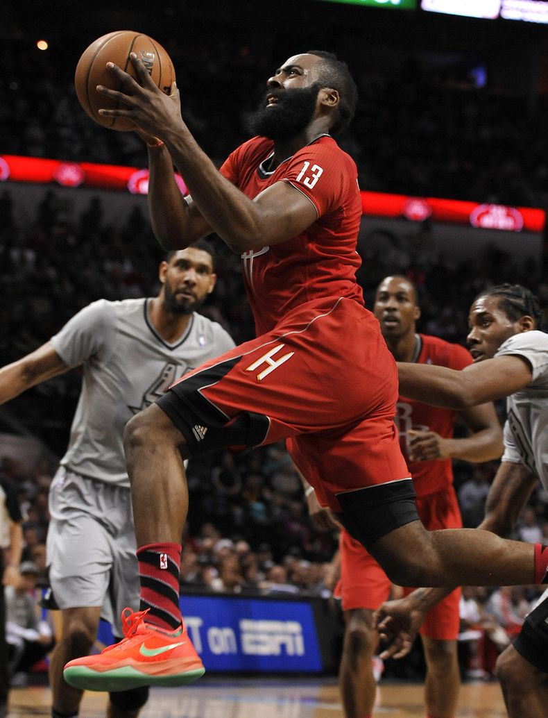 James Harden, escolta de los Rockets de Houston, dispara frente a Kawhi Leonard, de los Spurs de San Antonio, en el partido del mi&eacute;rcoles 25 de diciembre de 2013 (AP Foto/Darren Abate)