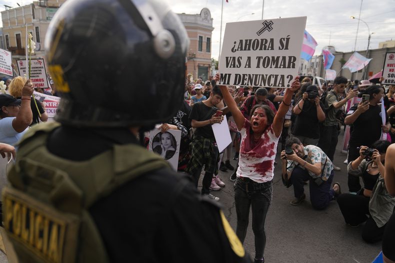 Una manifestante cubierta en sangre simulada protesta en apoyo a los derechos de las personas transgénero fuera de una sede policial en Lima, Perú, el jueves 13 de febrero de 2025. (AP Foto/Martín Mejía)