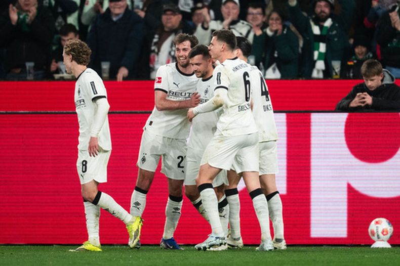 De izquierda a derecha: Hugo Bolin, Joe Scally, el goleador Kevin Stöger, Yannik Engelhardt y Kevin Diks, del Mönchengladbach, celebran tras marcar el primer gol durante el partido de la Bundesliga alemana entre el Borussia Mönchengladbach y el FC St. Pauli, en Mönchengladbach, Alemania, el viernes 13 de marzo de 2026. (Marius Becker/dpa vía AP)