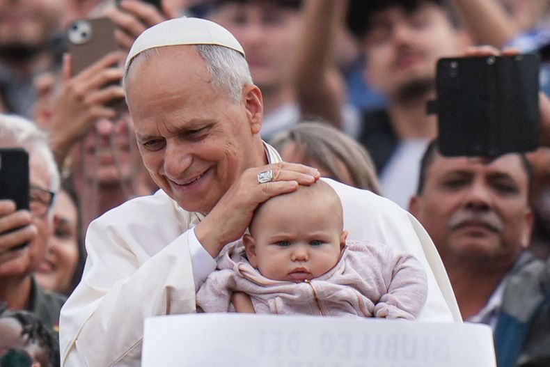 El papa León XIV bendice a un bebé al final de una misa por el Jubileo de los Migrantes y Misioneros en la Plaza de San Pedro en el Vaticano, el domingo 5 de octubre de 2025. (AP Foto/Alessandra Tarantino)