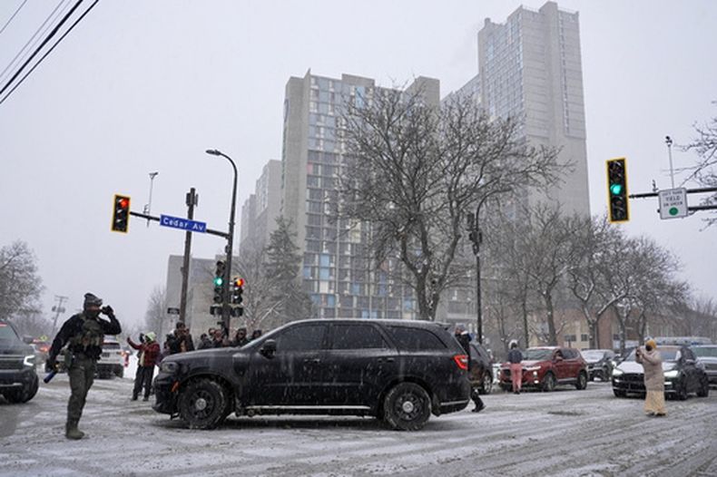 Activistas confrontan a un grupo de agentes del Servicio de Inmigración y Control de Aduanas en el barrio mayoritariamente somalí de Cedar-Riverside, en Minneapolis, el martes 9 de diciembre de 2025. (AP Foto/Mark Vancleave)