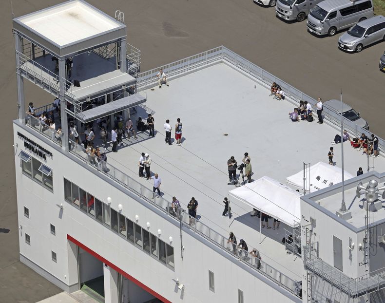 Varias personas se refugian en la azotea de una estación de bomberos en Mukawa, en Hokkaido, en el norte de Japón, el 30 de julio de 2025, luego de que un potente sismo en el extremo oriental de Rusia provocó una alerta de tsunami en algunas zonas de Japón. (Kyodo News vía AP)