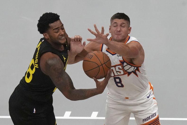 Brice Sensabaugh del Jazz de Utah, izquierda, y Grayson Allen (8) de los Suns de Phoenix pelean por el balón durante la primera mitad en la NBA Cup, el martes 12 de noviembre de 20204, en Salt Lake City. (AP Photo/Rick Bowmer)
